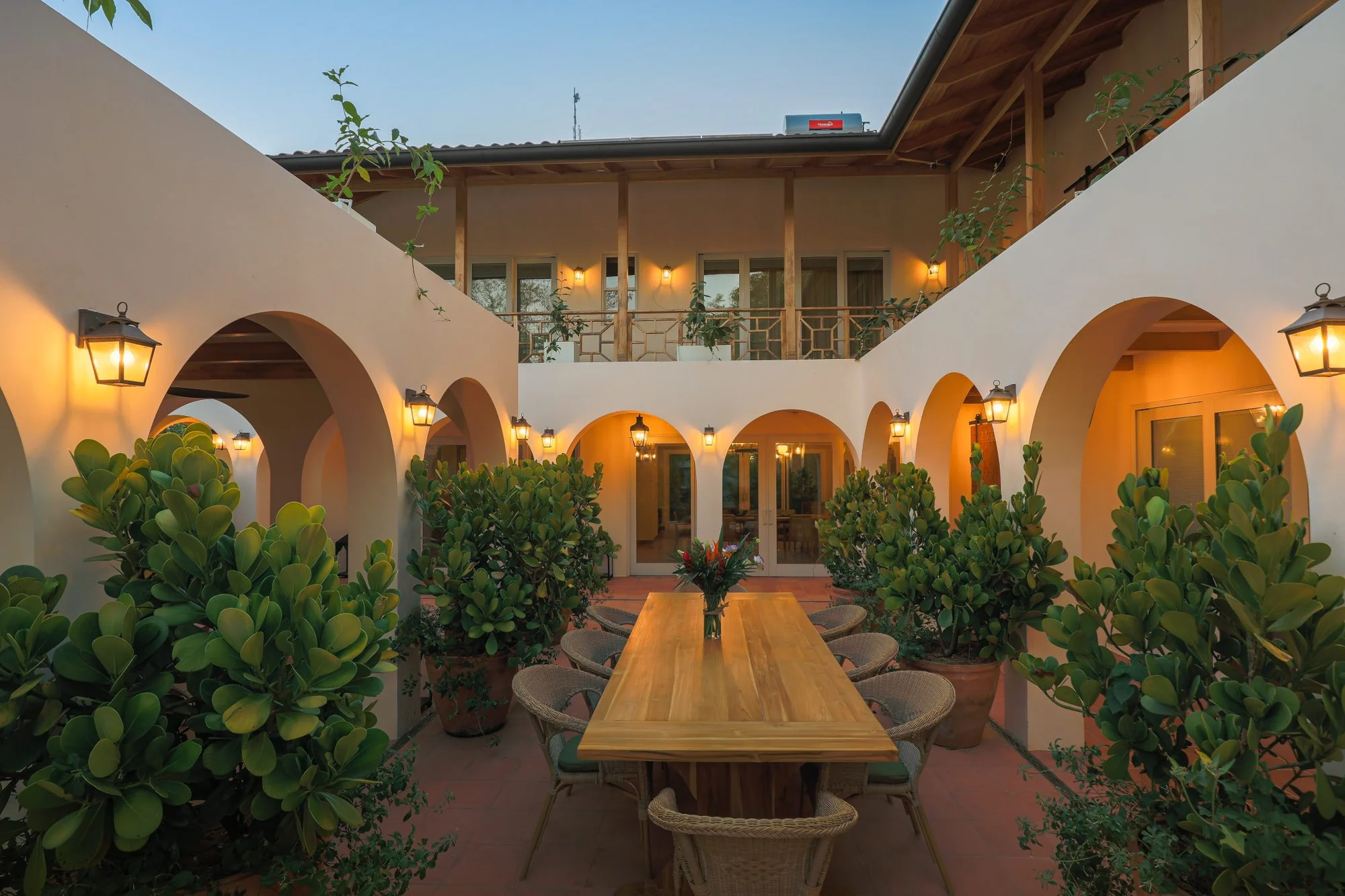 Casa Oceanus villa Mediterranean courtyard with long communal dining table and arched walkways, Guiones Beach Club Nosara, Costa Rica