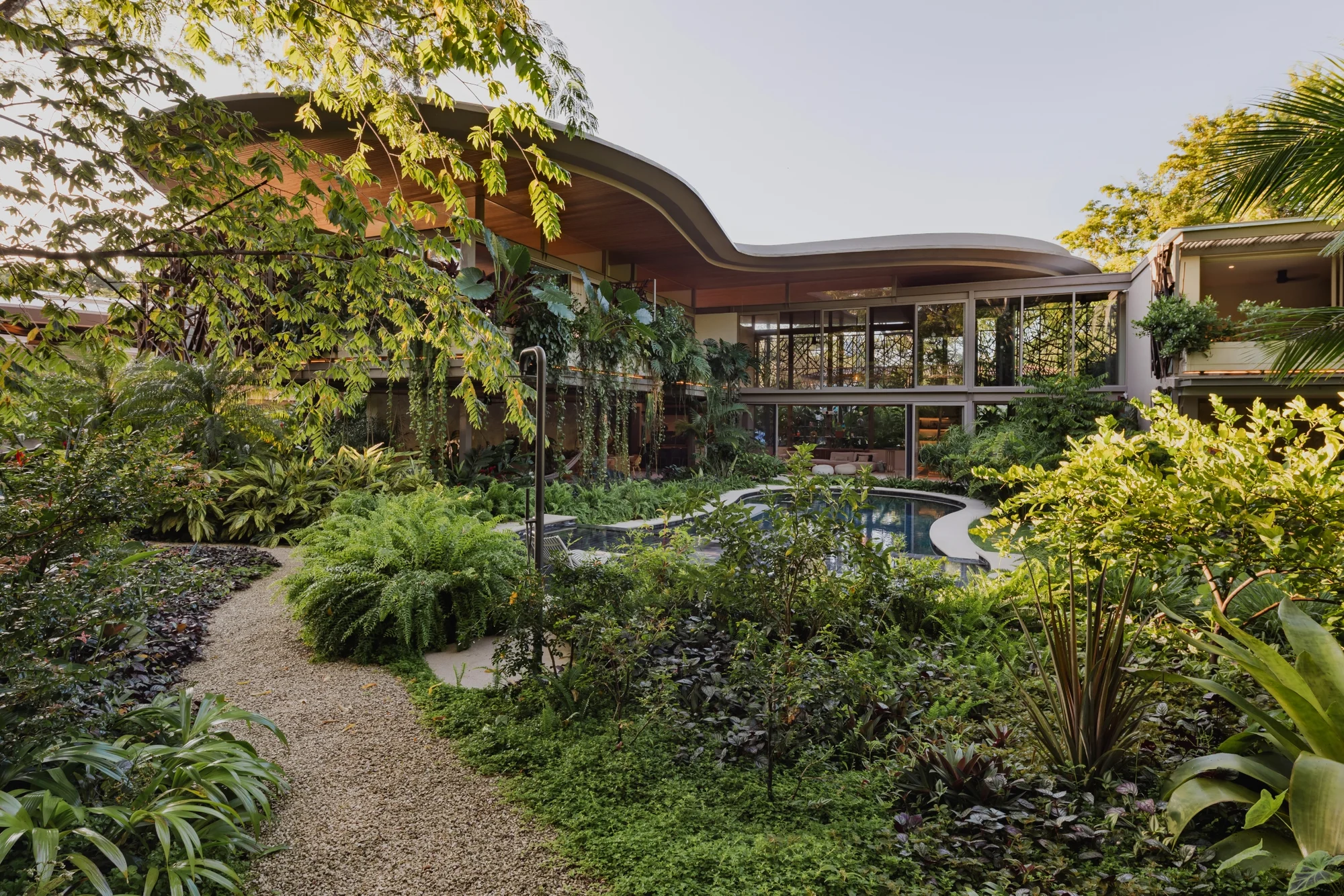 SEN villa aerial view of sculpted curved hardwood roof above tropical gardens, Pelada Beach Nosara, Costa Rica