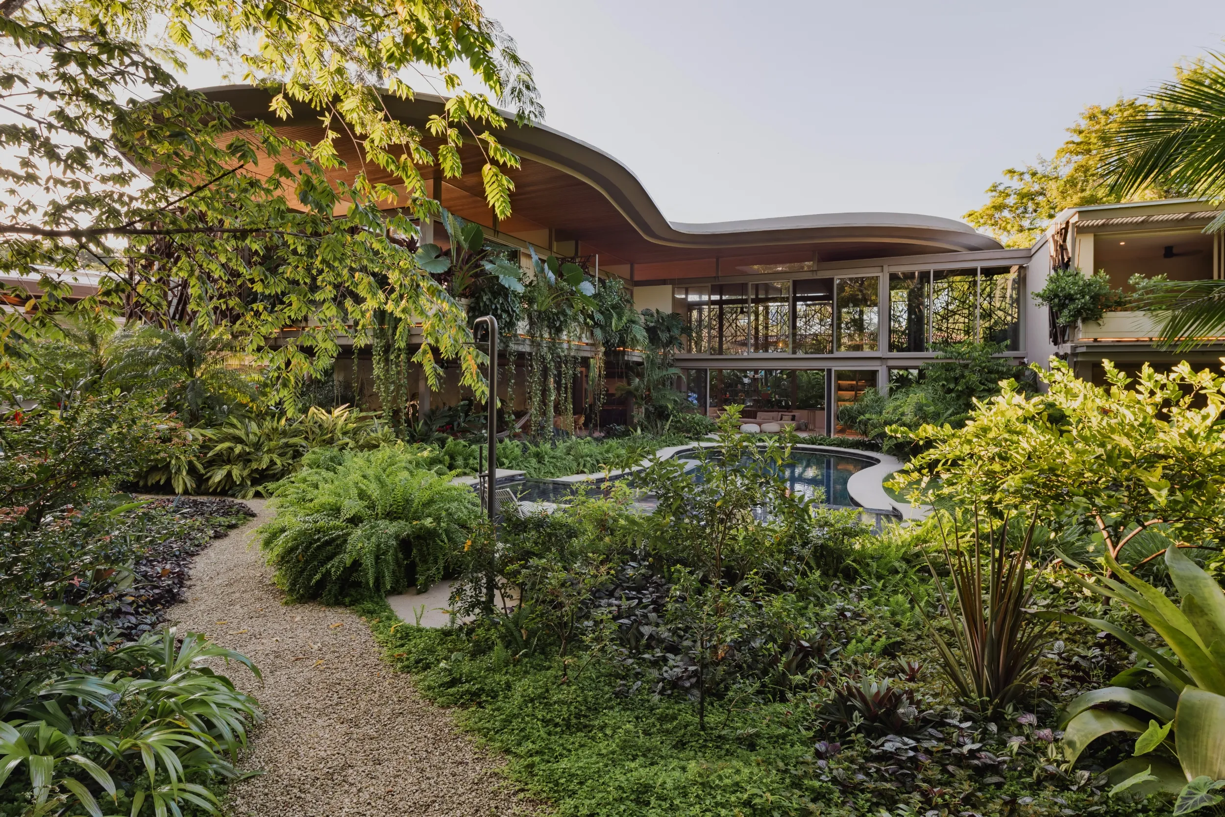 SEN villa aerial view of sculpted curved hardwood roof above tropical gardens, Pelada Beach Nosara, Costa Rica