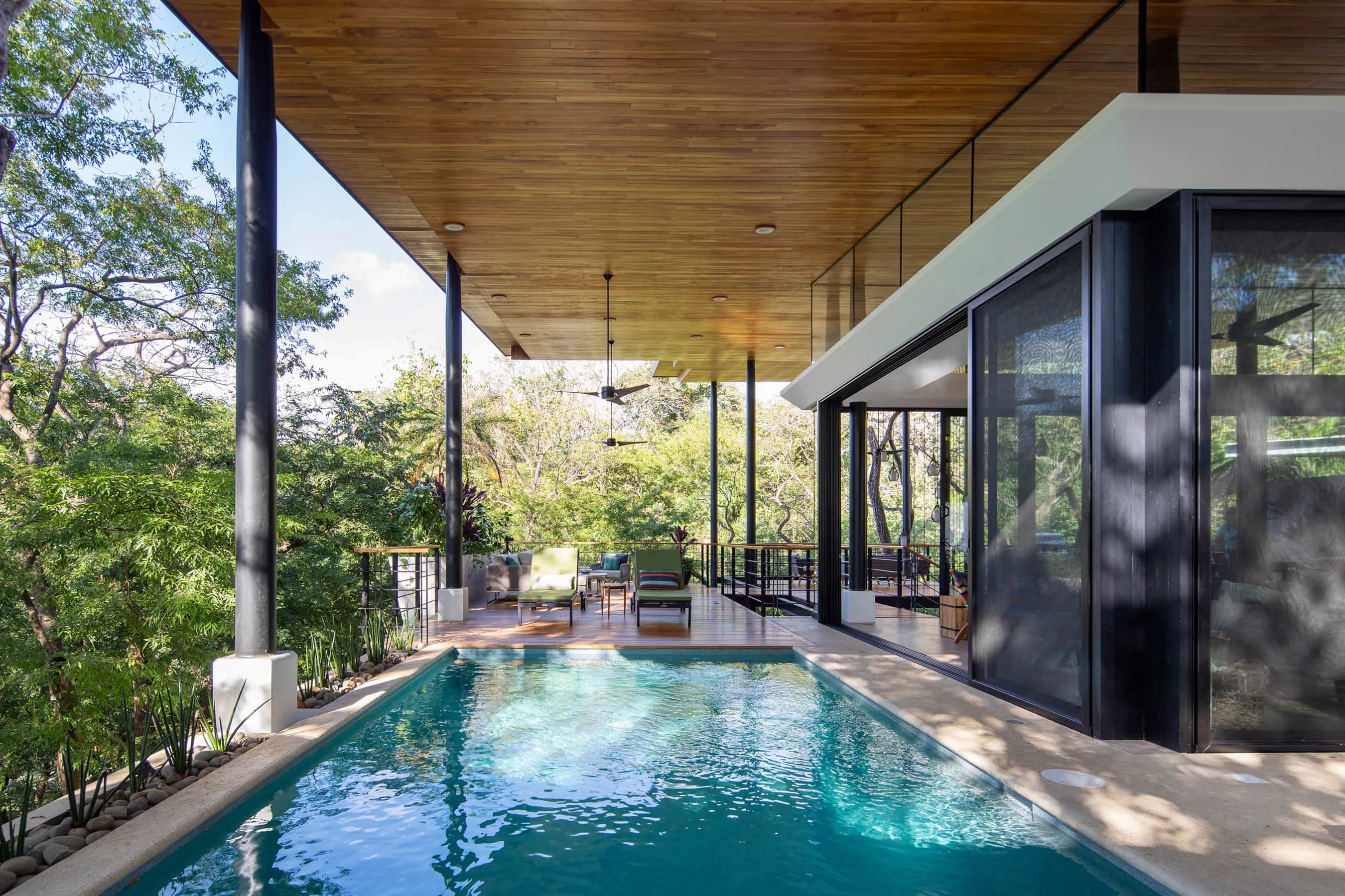 Terrace House villa pool with covered roof overhang surrounded by jungle, Studio Saxe design, Nosara