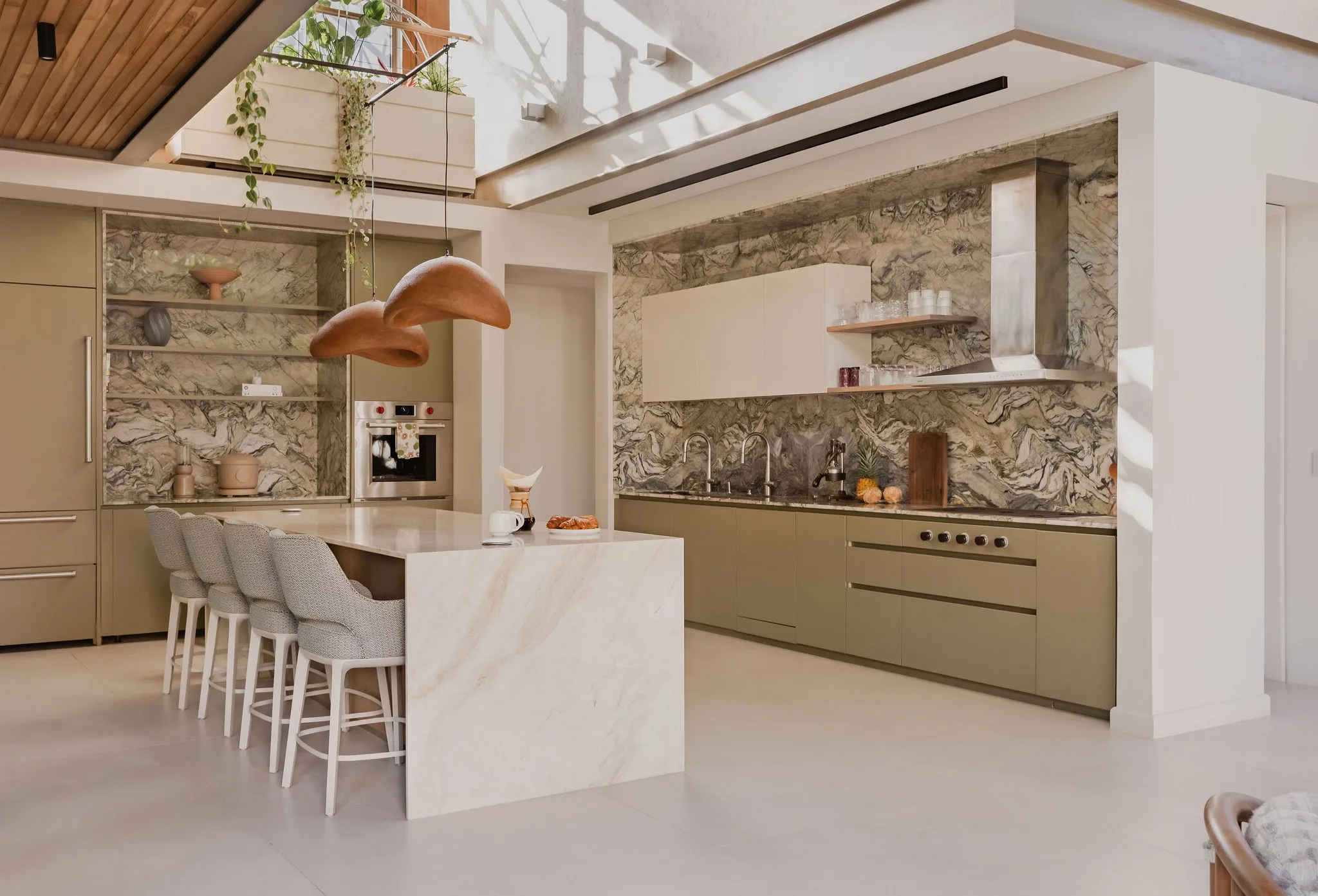 SEN villa gourmet kitchen with green stone walls and marble island, Pelada Beach Nosara