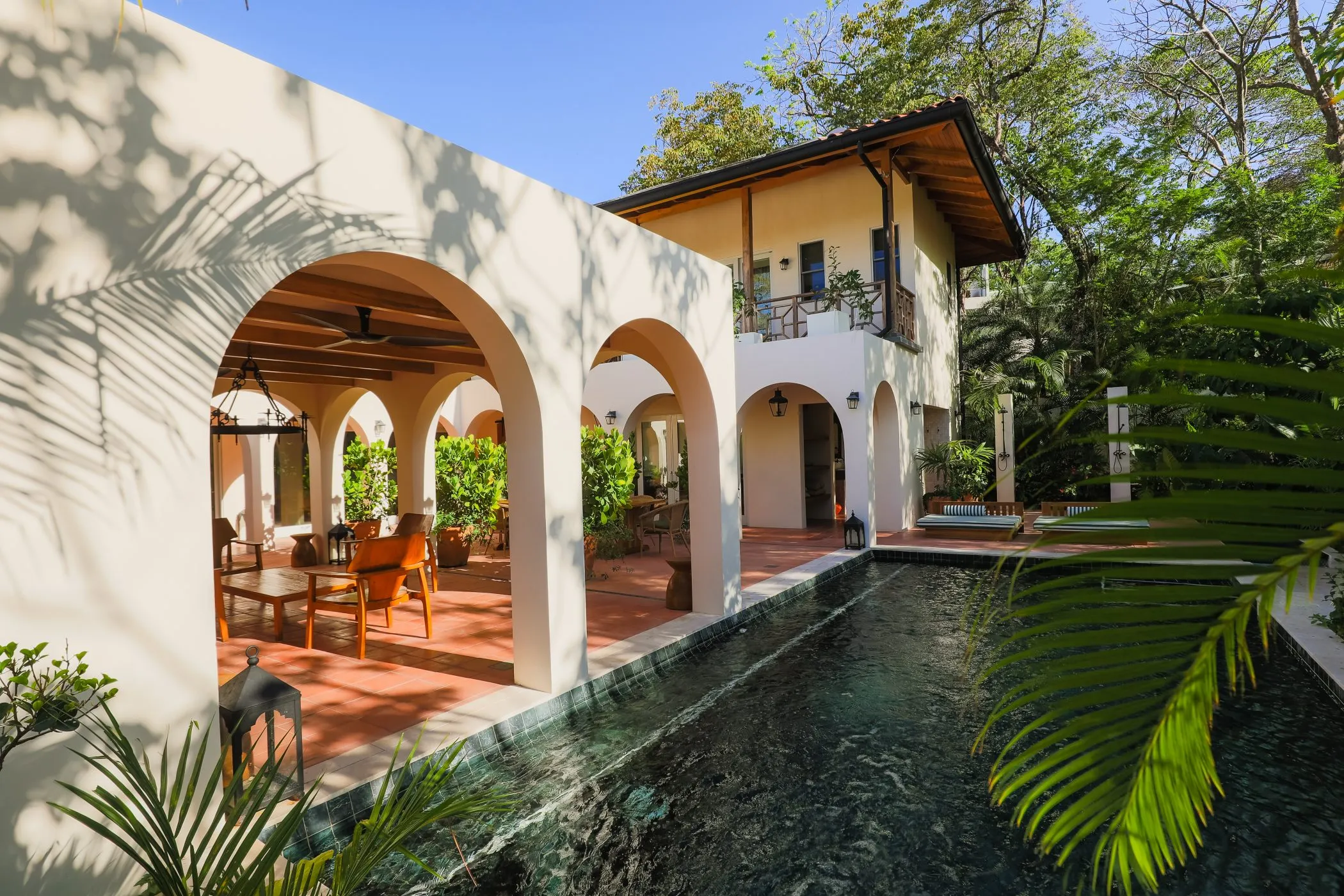 Casa Oceanus villa saltwater pool reflecting the archways and palms, Nosara