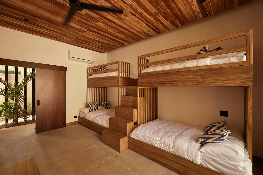 Calma House villa bunk room with bunks and white linens, Playa Guiones Nosara