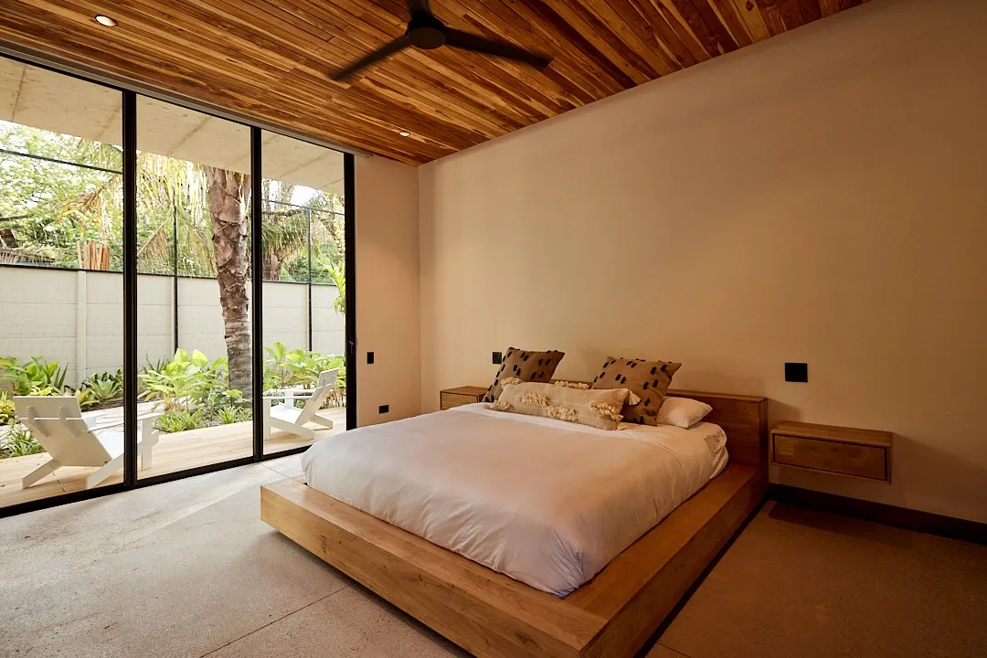 Calma House villa bedroom with sliding glass to the outdoor area, Nosara