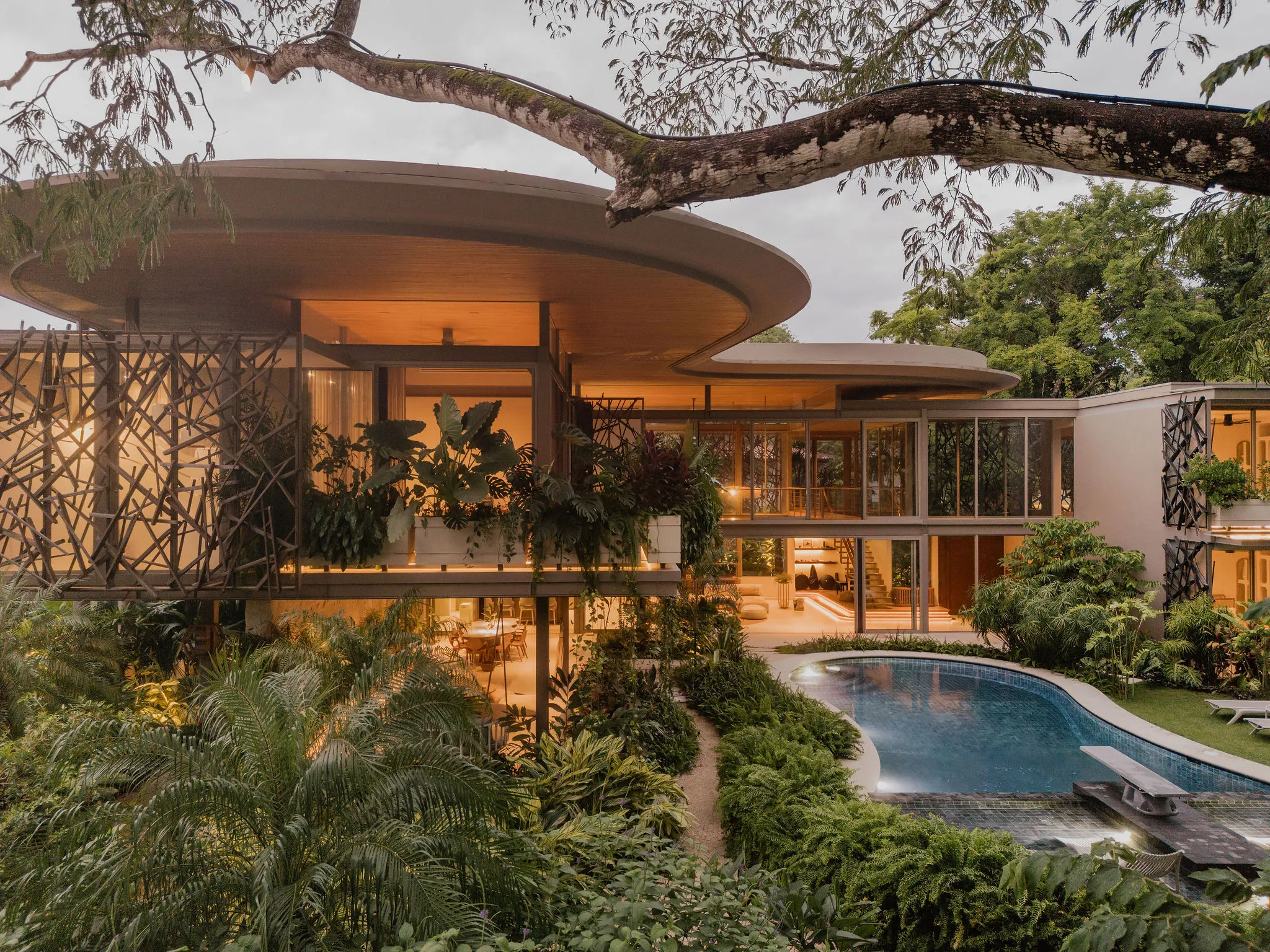SEN villa pool reflecting the curved architecture at evening, Nosara
