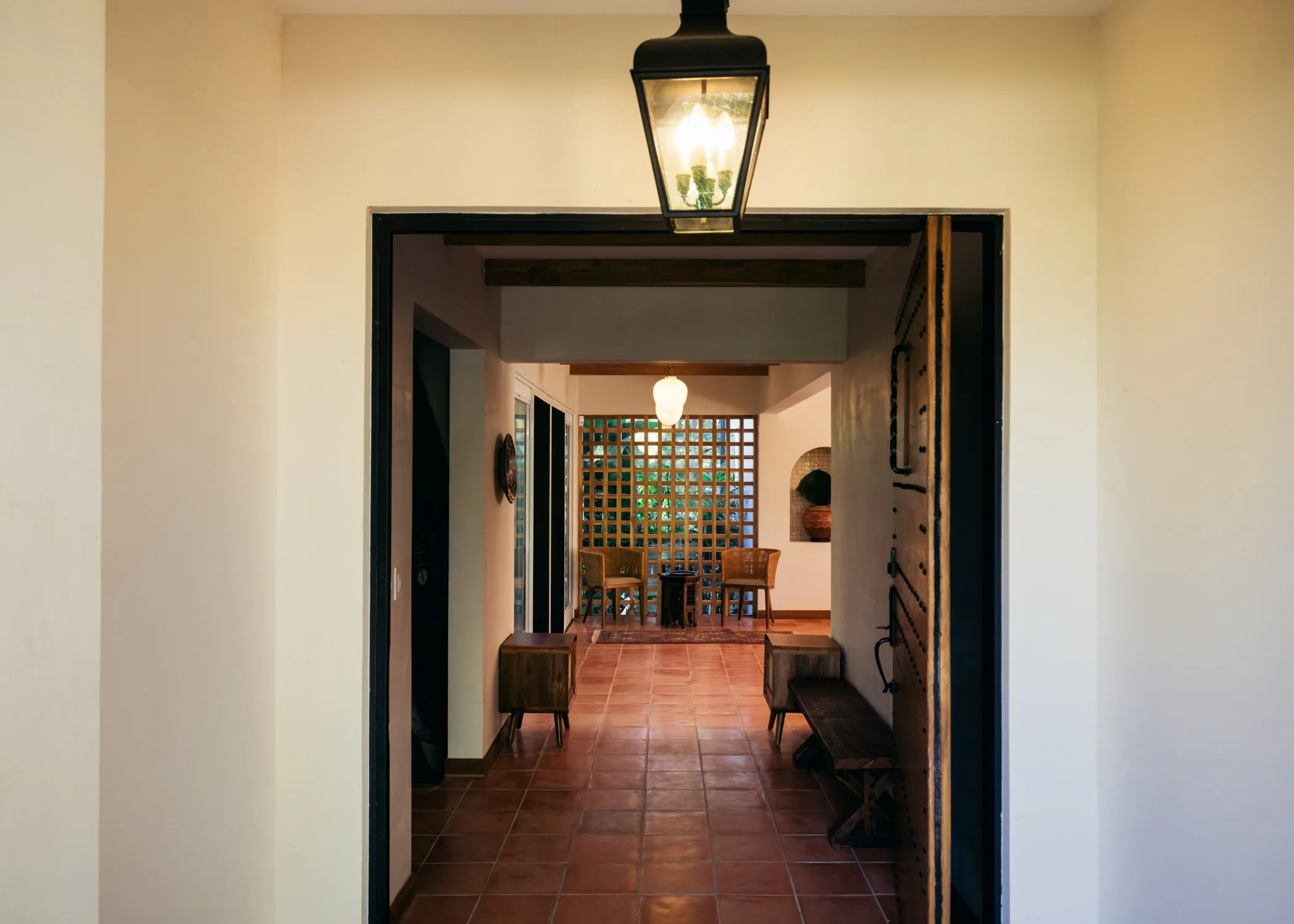 Casa Oceanus villa hallway with arched openings and lantern lighting, Nosara